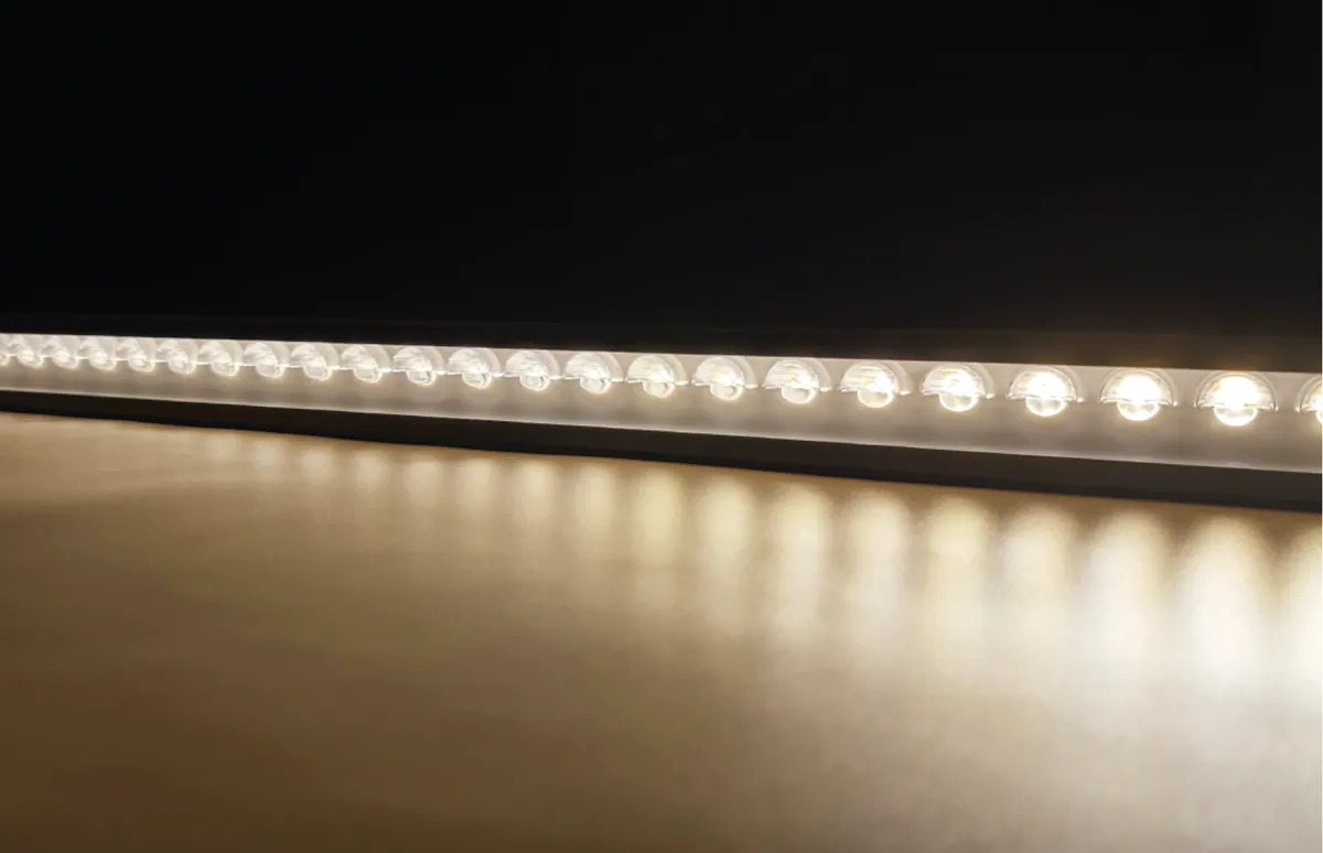Row of AI-WW-EA lenses lit in warm white, washing the surface below