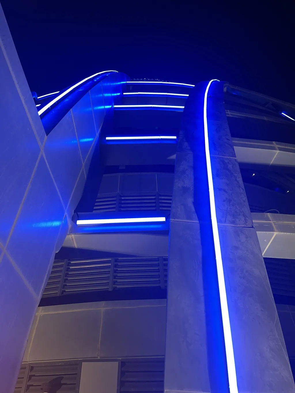 Illustrative application photo: Blue linear lighting following the curved edges of a building façade at night.
