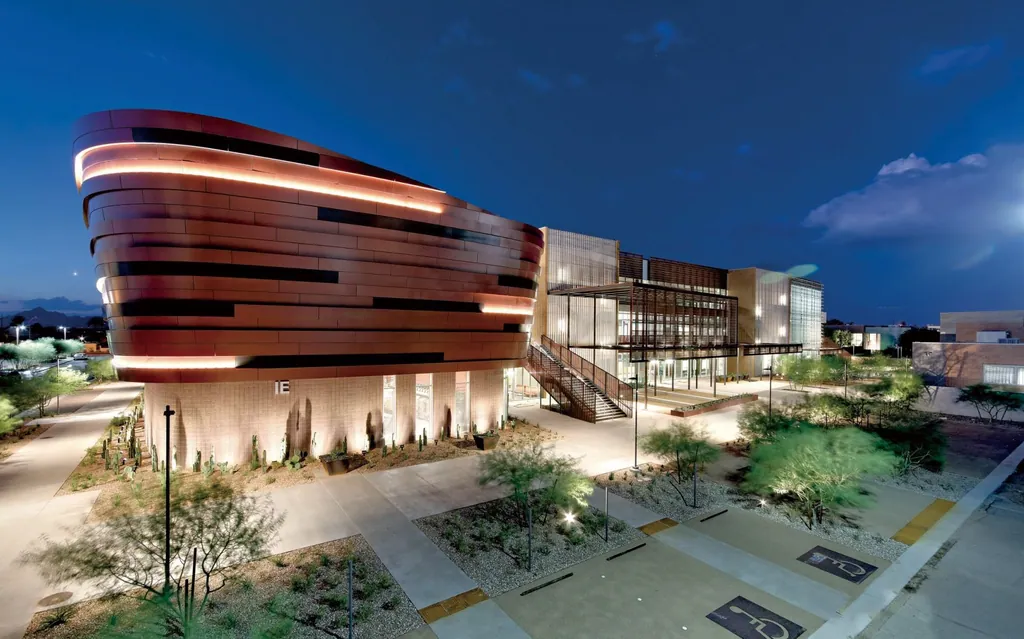Illustrative application photo: Warm-white light lines along the curved cladding bands of a building at dusk.