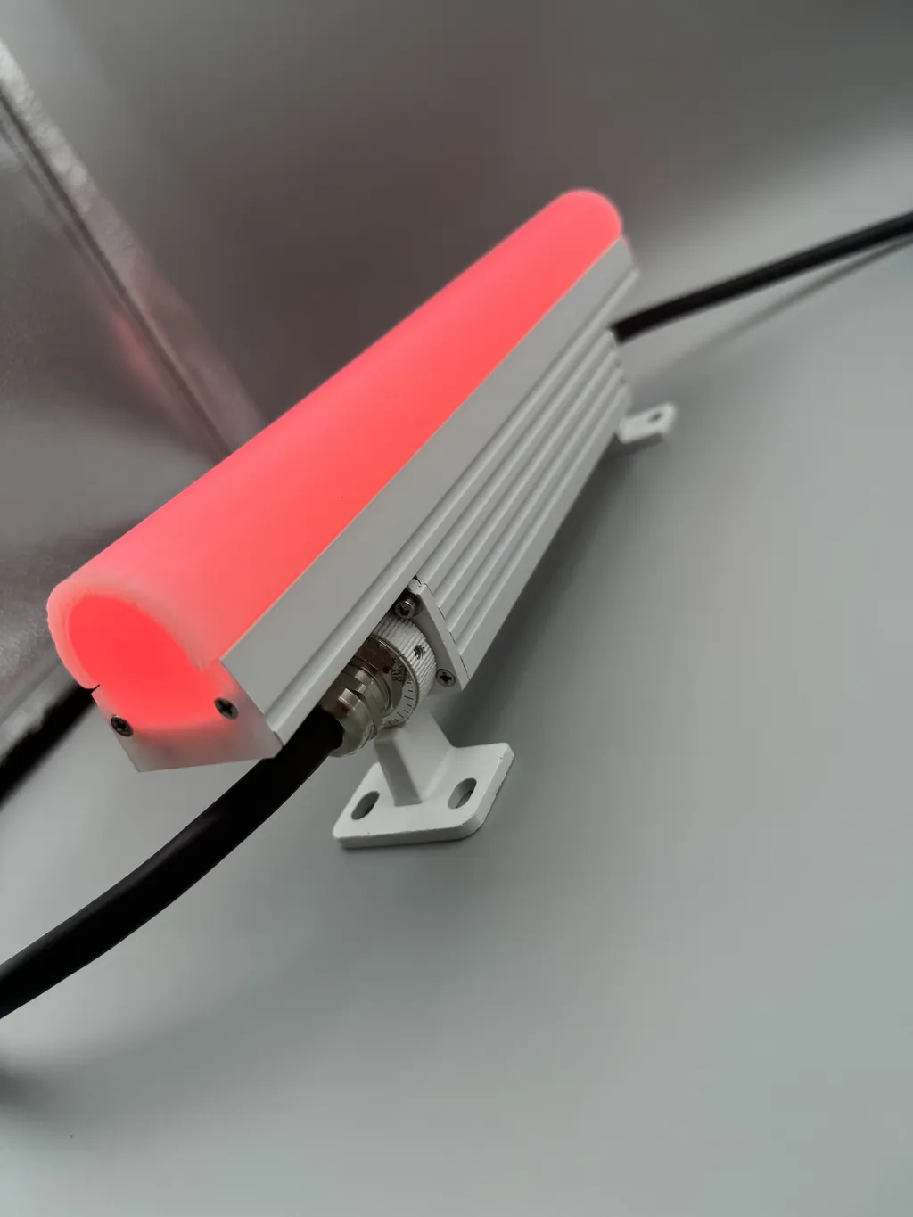 Short bar lit red, showing the arched end cap and cable gland.