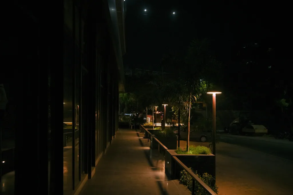 A line of disc post tops along the building frontage at night