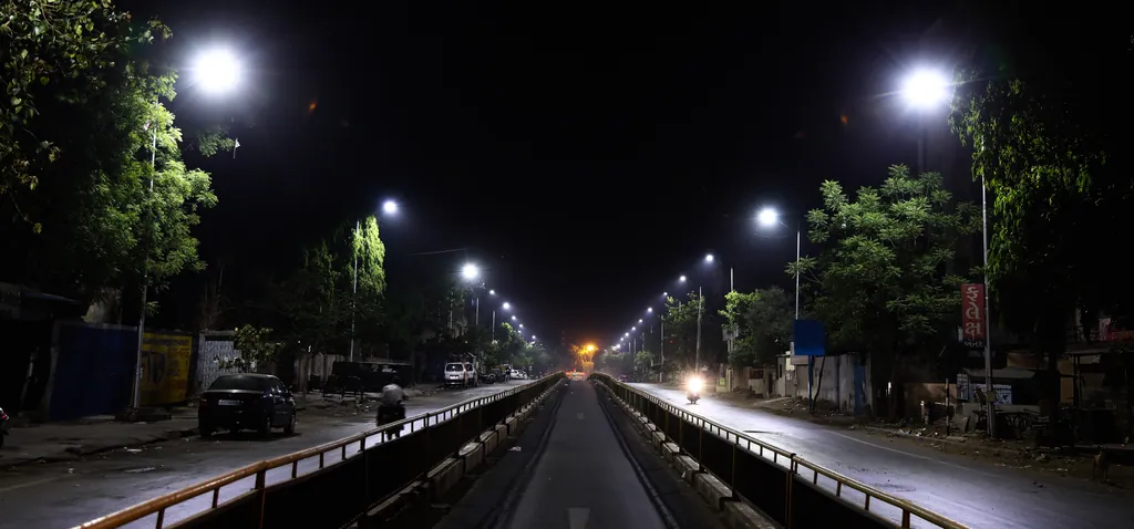 The central bus lane between railings at night, with street lights on both sides