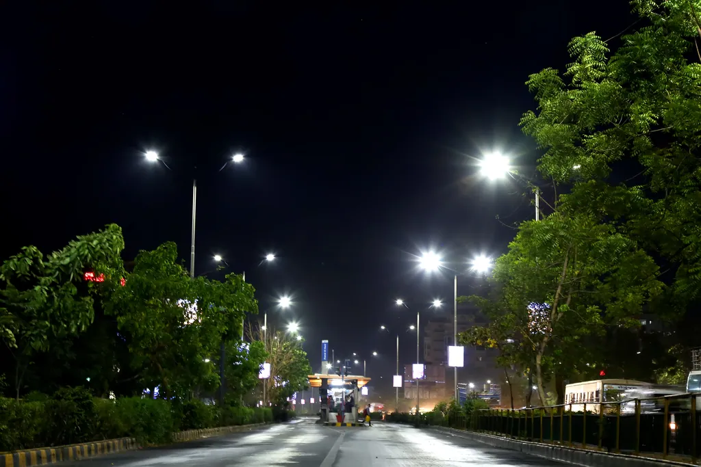 The bus lane leading to a BRTS station at night, lit by double-arm street lights
