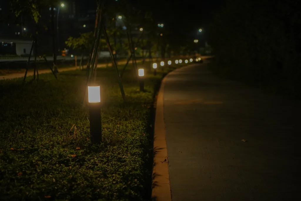Bollards with opal diffusers along a curving park path at night