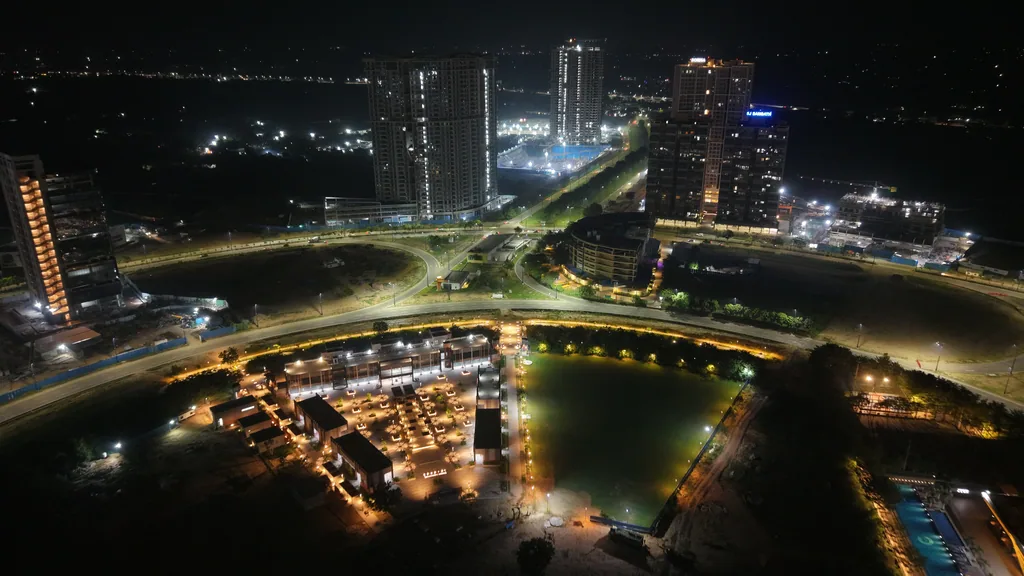 Night aerial of Central Park with the towers of GIFT City behind