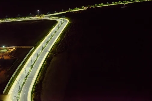 Aerial view of street lights along a curving road in GIFT City at night