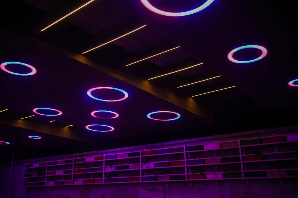 Coloured rings beside a beam lit with warm linear lights under Nehru Bridge