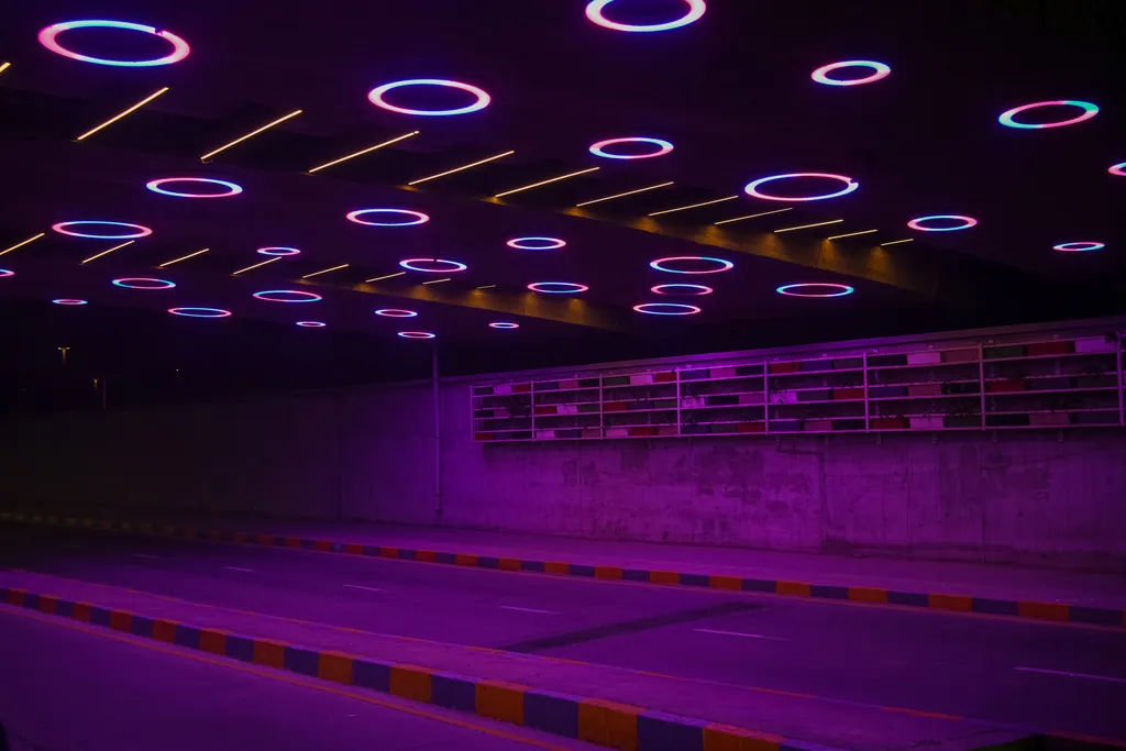 Lit rings above the road and a planted wall beneath Nehru Bridge