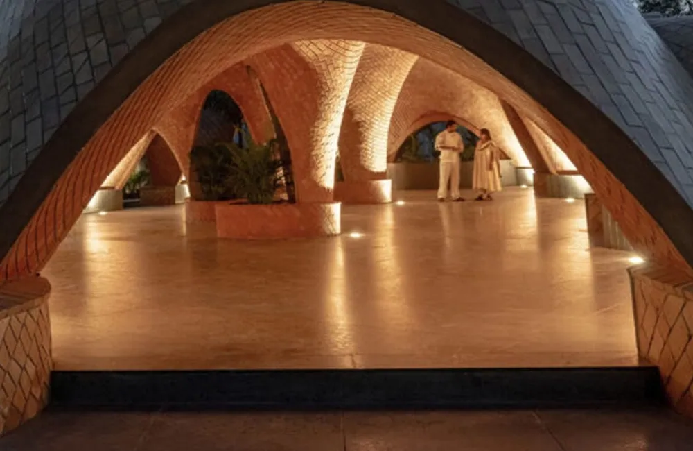 Inside the vaults at Nilaya: in-ground lights wash the brick piers and arches