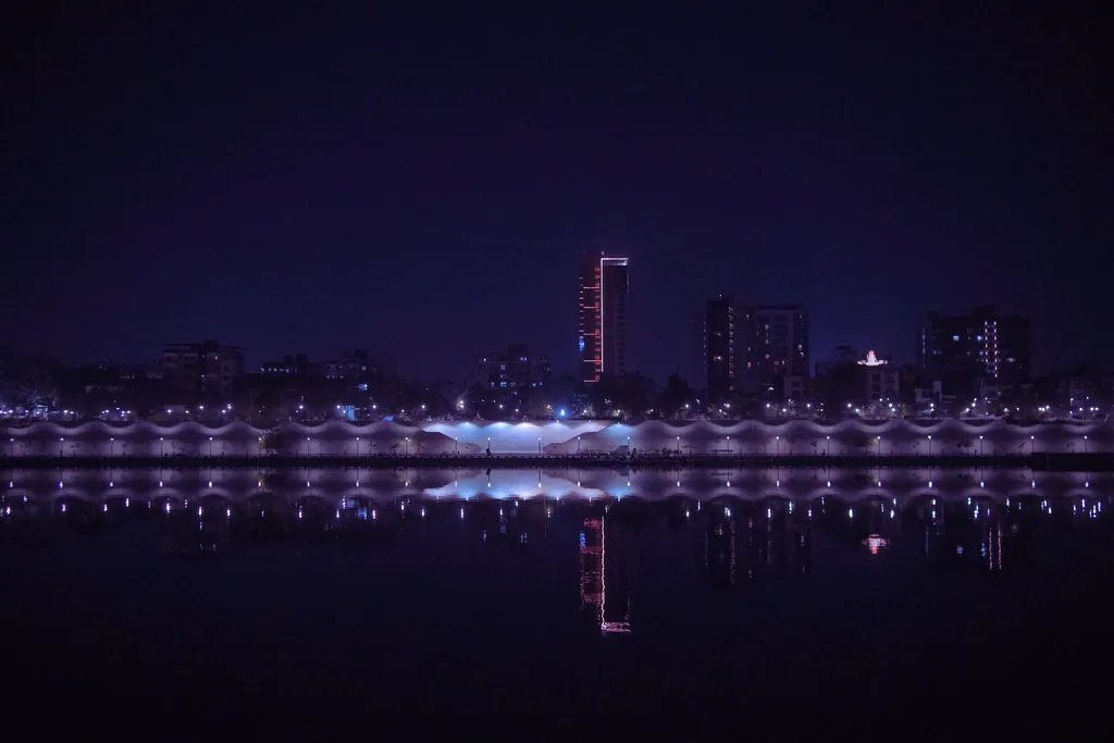 The Sabarmati Riverfront at night, seen across the river, its lights reflected in the water