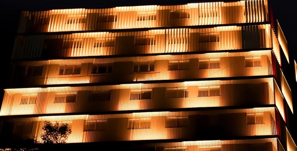 Close view of lit vertical fins across the upper floors of Sakar-IX