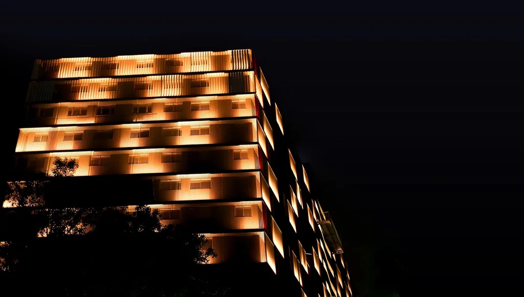 Sakar-IX at night, warm light grazing the vertical fins on each floor