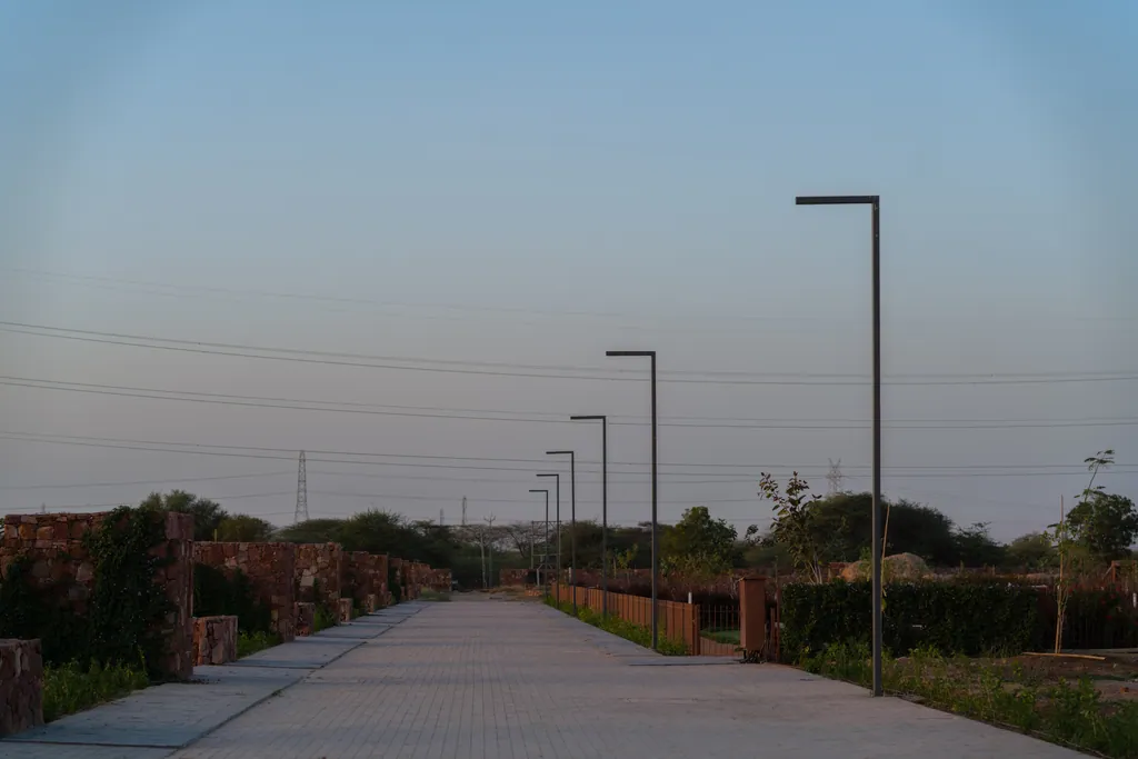 Paved promenade lined with single-arm light poles and stone walls