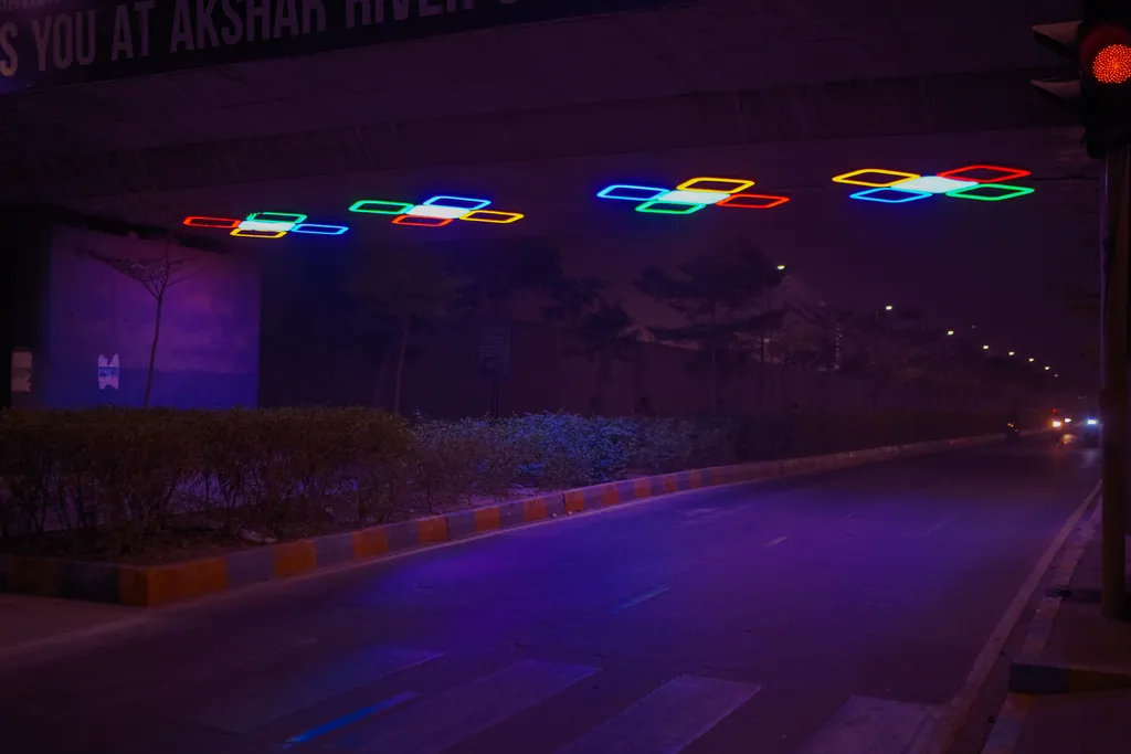 The row of lit clusters under the bridge, seen from the kerb at night